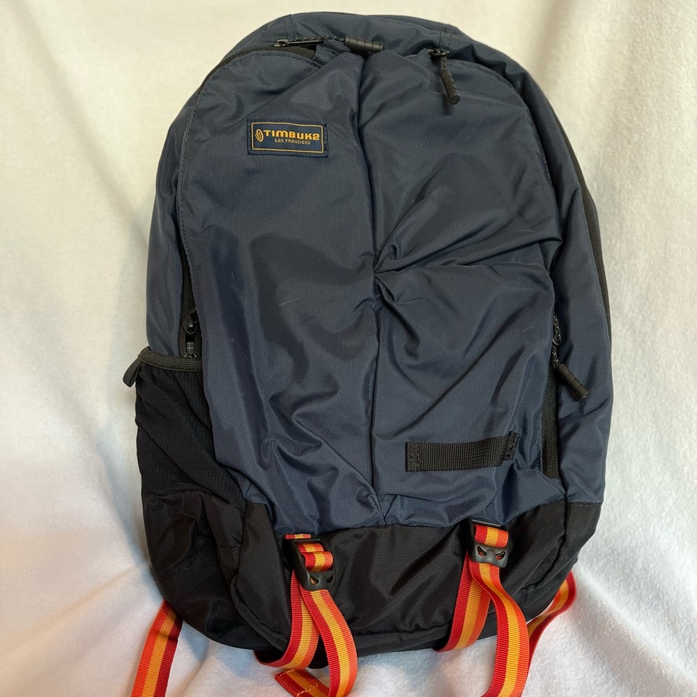 TIMBUK2 "Showdown" Backpack - Navy Blue with orange and red striped accents.